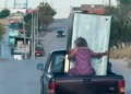 VIDEO: Abuelita intenta sostener un refrigerador en una camioneta en movimiento y termina en el pavimento