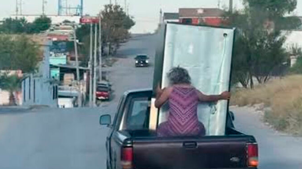 VIDEO: Abuelita intenta sostener un refrigerador en una camioneta en movimiento y termina en el pavimento